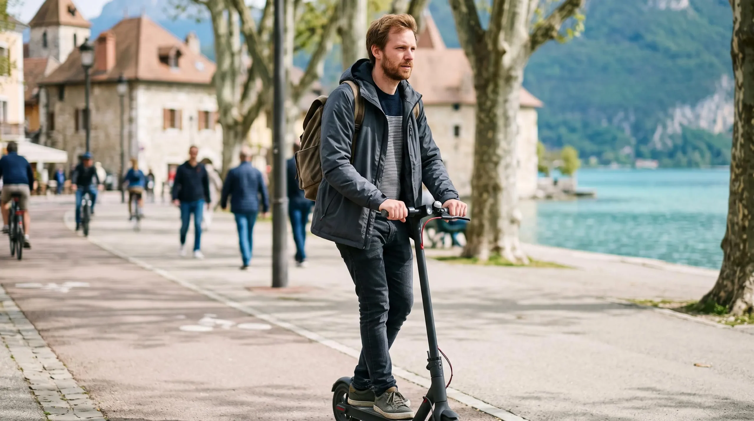 Personne utilisant une trottinette électrique sur une piste cyclable à Annecy